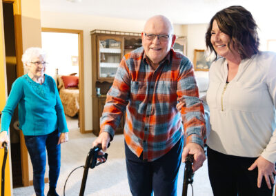 Senior man and wife and adult daughter smiling