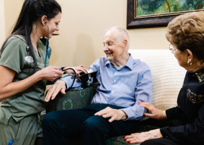A nurse taking a blood pressure reading from a senior man