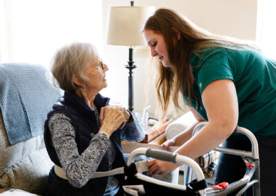 Image of a nurse helping a senior woman use her walker