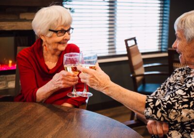 Two senior women Cheering their glasses of wine