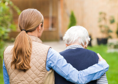 adult woman with arm around senior man